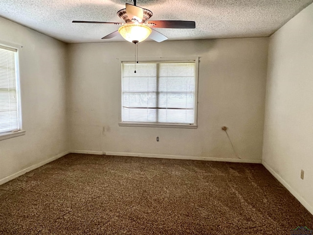 carpeted spare room featuring ceiling fan and a textured ceiling