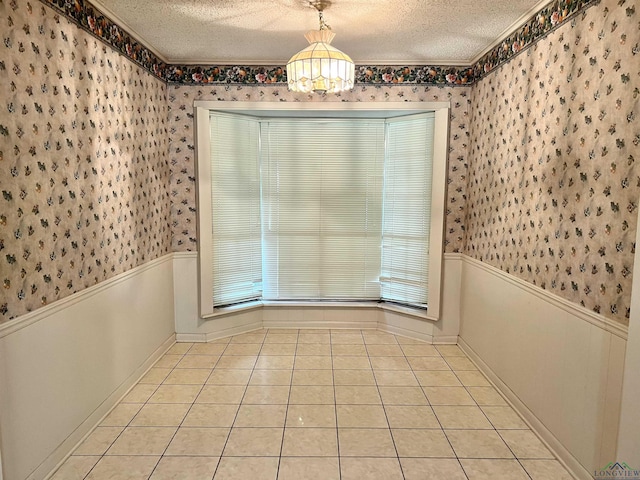 unfurnished dining area featuring a chandelier, light tile patterned floors, and a textured ceiling