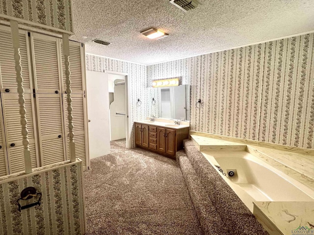 bathroom with vanity, a bath, and a textured ceiling