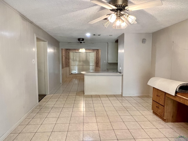 kitchen with a textured ceiling, ceiling fan, and light tile patterned flooring