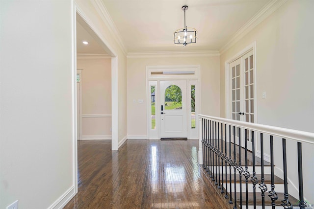 entrance foyer with baseboards, ornamental molding, wood finished floors, and a chandelier