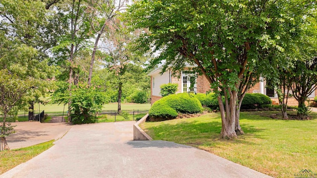 view of property's community with a yard and fence