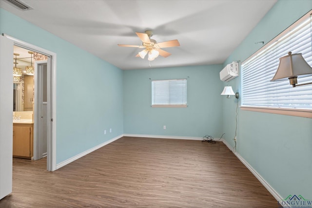 1800 Shady Ln, Longview, TX 75604 - unfurnished bedroom with wood finished floors, an AC wall unit, baseboards, a sink, and a ceiling fan