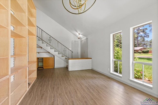 1800 Shady Ln, Longview, TX 75604 - unfurnished living room featuring wood finished floors, plenty of natural light, lofted ceiling, and baseboards