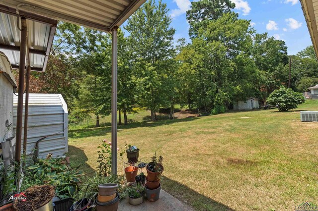 view of yard with central AC and a storage shed