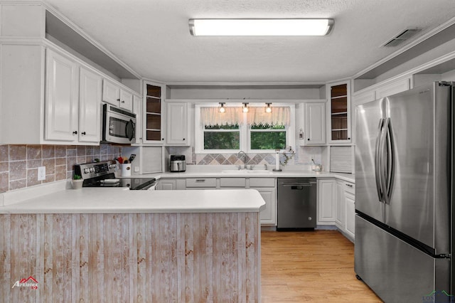 kitchen featuring white cabinets, sink, kitchen peninsula, and stainless steel appliances