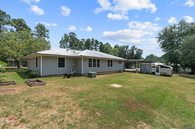 rear view of property with a lawn, central AC unit, and a carport