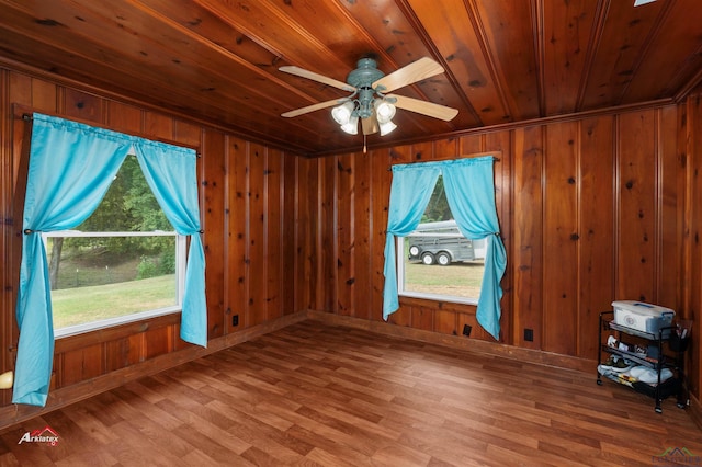 unfurnished room with wood walls, ceiling fan, wood ceiling, and hardwood / wood-style flooring