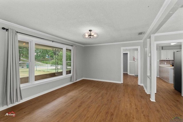 unfurnished room with ornamental molding, a textured ceiling, and hardwood / wood-style flooring