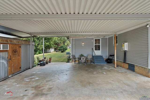 view of patio with a carport and a wall unit AC