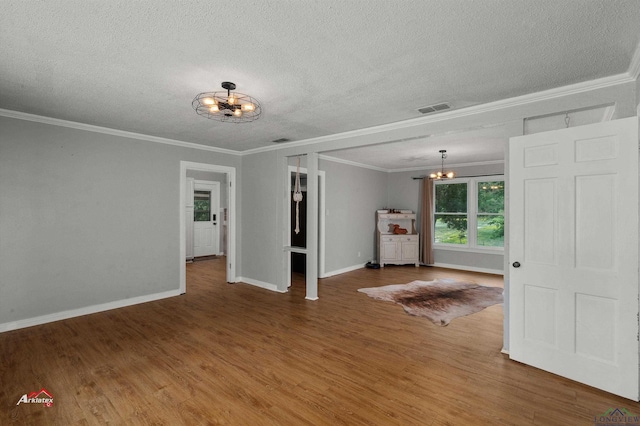 unfurnished room featuring crown molding, a chandelier, a textured ceiling, and hardwood / wood-style flooring