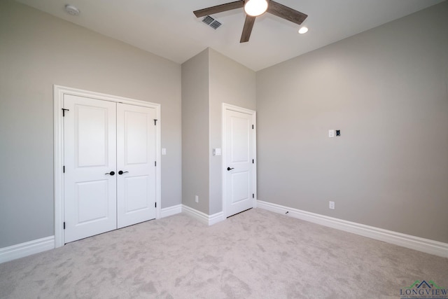 unfurnished bedroom with ceiling fan, light colored carpet, and a closet