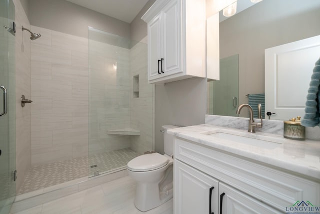 bathroom featuring a shower with door, toilet, vanity, and tile patterned flooring