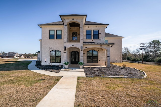 mediterranean / spanish-style house featuring a front yard and french doors