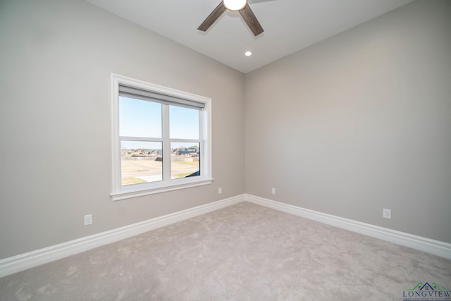 spare room featuring ceiling fan and light colored carpet