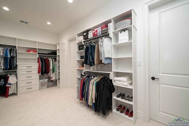 walk in closet featuring light carpet