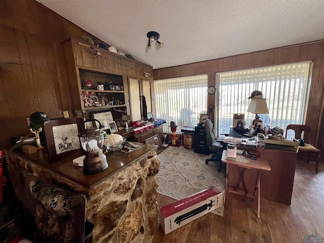 office space with a textured ceiling and wood walls