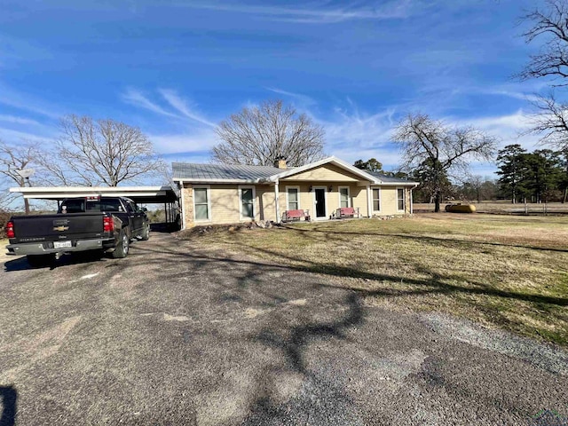 view of front of home with a front yard and a carport