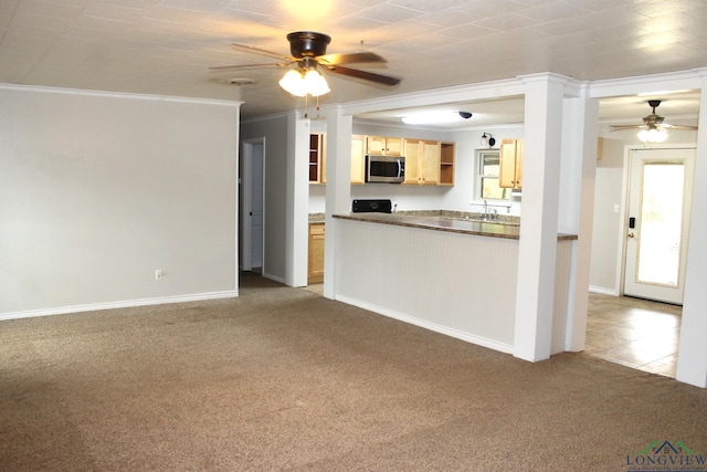 kitchen featuring light brown cabinetry, light colored carpet, ceiling fan, and crown molding