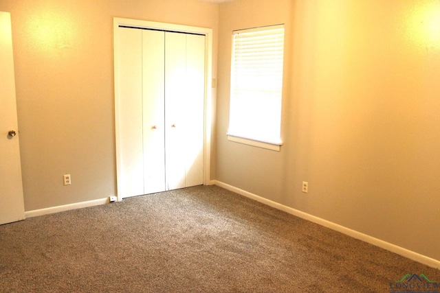 unfurnished bedroom featuring carpet and a closet