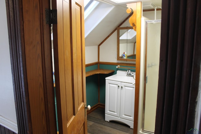 bathroom with vanity, wood-type flooring, and vaulted ceiling