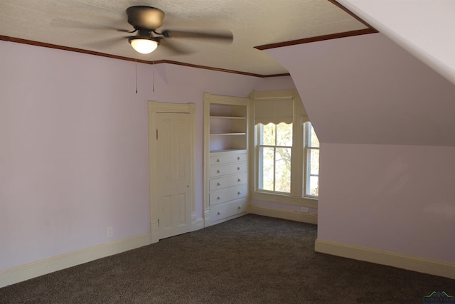 bonus room featuring dark colored carpet, ceiling fan, built in features, and vaulted ceiling