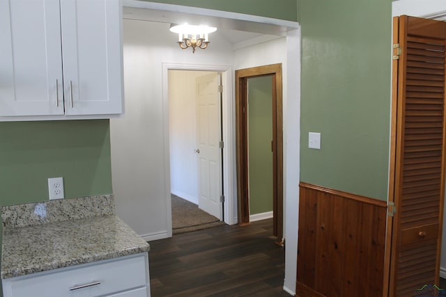 interior space with wooden walls, dark hardwood / wood-style flooring, and an inviting chandelier