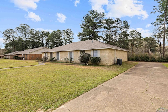 ranch-style house featuring brick siding, cooling unit, and a front yard