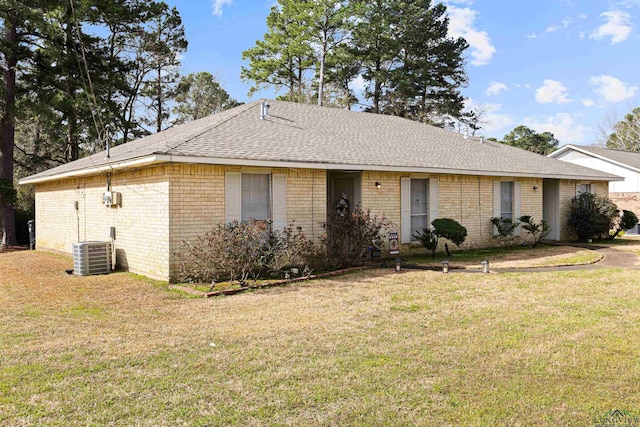 ranch-style home with a front lawn, central AC unit, brick siding, and a shingled roof