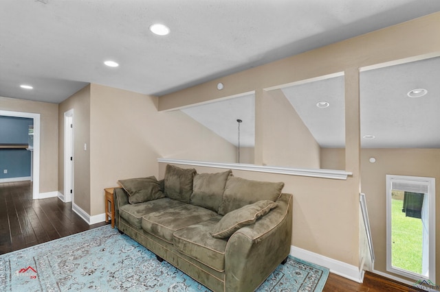 living room with dark hardwood / wood-style flooring and vaulted ceiling