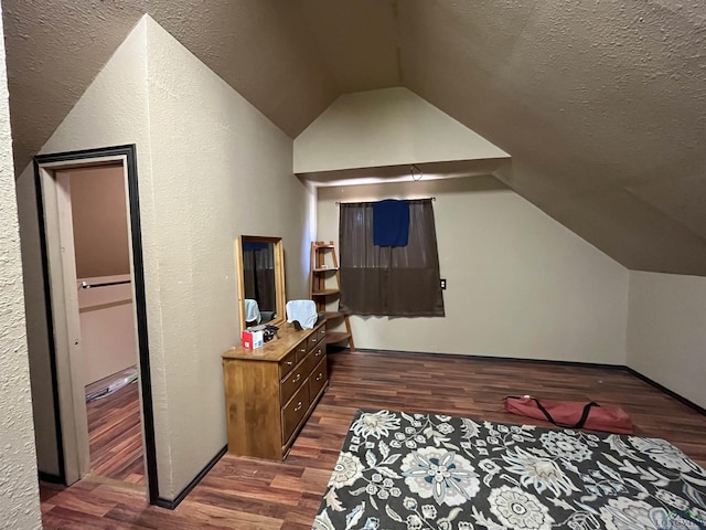 additional living space with lofted ceiling, a textured ceiling, and dark wood-type flooring