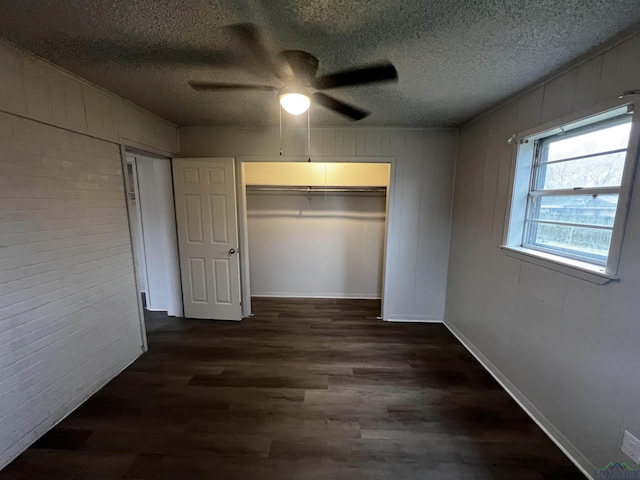 unfurnished bedroom with ceiling fan, dark hardwood / wood-style floors, a textured ceiling, and a closet