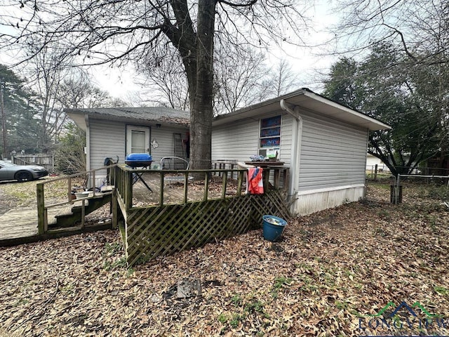 rear view of house featuring a wooden deck