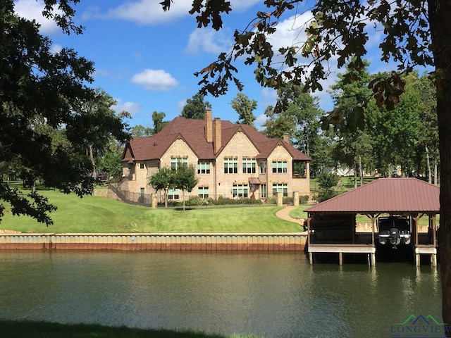 back of property featuring a water view and a yard