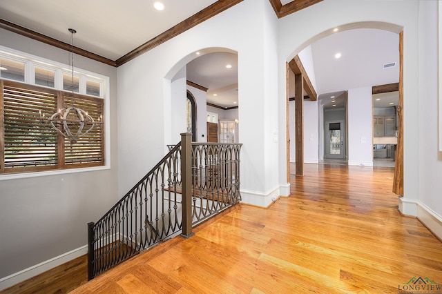 hall featuring ornamental molding and light hardwood / wood-style floors