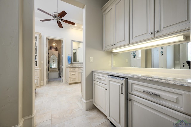 kitchen with light stone countertops and ceiling fan