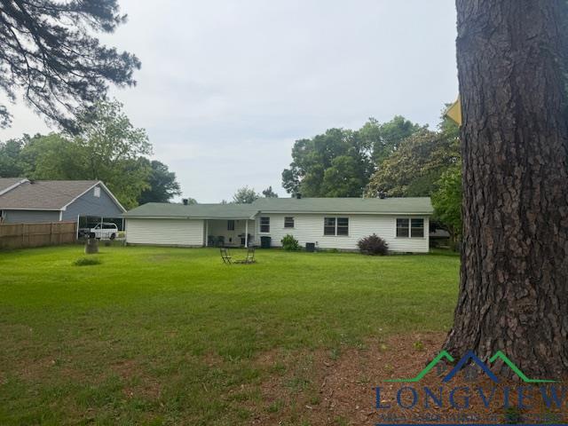 115 Bryant St, Longview, TX 75605 - rear view of property featuring a lawn