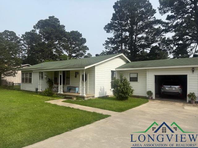 115 Bryant St, Longview, TX 75605 - single story home featuring covered porch, driveway, a front lawn, and an attached garage