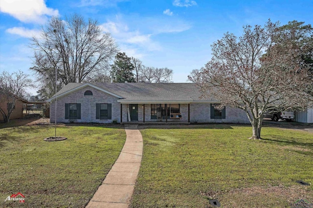 view of front of property featuring brick siding, a porch, a front yard, and a shingled roof