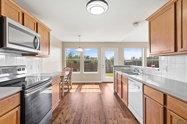 kitchen with backsplash, sink, pendant lighting, and appliances with stainless steel finishes