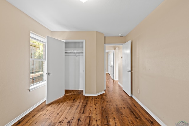 unfurnished bedroom with hardwood / wood-style floors and a closet