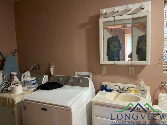 laundry room featuring washer and clothes dryer, a wealth of natural light, and sink