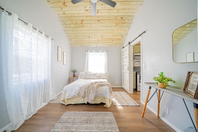 bedroom with ceiling fan, a barn door, hardwood / wood-style floors, vaulted ceiling, and wood ceiling