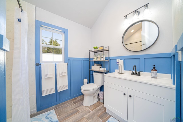 bathroom with a shower with shower curtain, vanity, toilet, and lofted ceiling