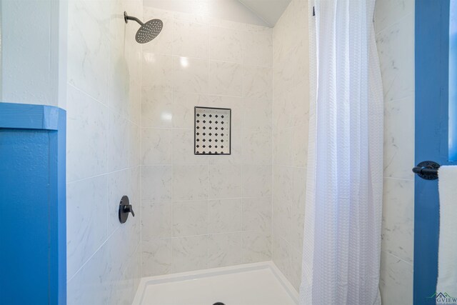 bathroom featuring vaulted ceiling and curtained shower