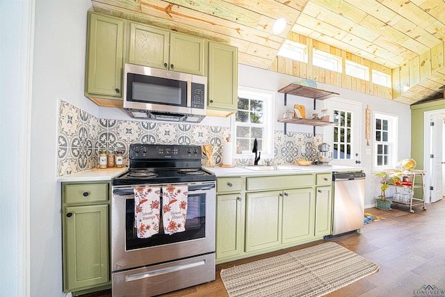 kitchen featuring decorative backsplash, appliances with stainless steel finishes, and green cabinets