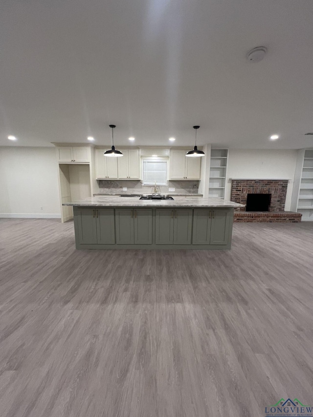 kitchen with open floor plan, a fireplace, wood finished floors, and white cabinetry