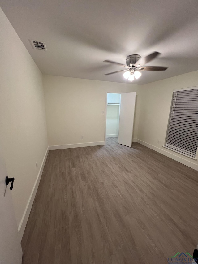 interior space with baseboards, visible vents, ceiling fan, and wood finished floors