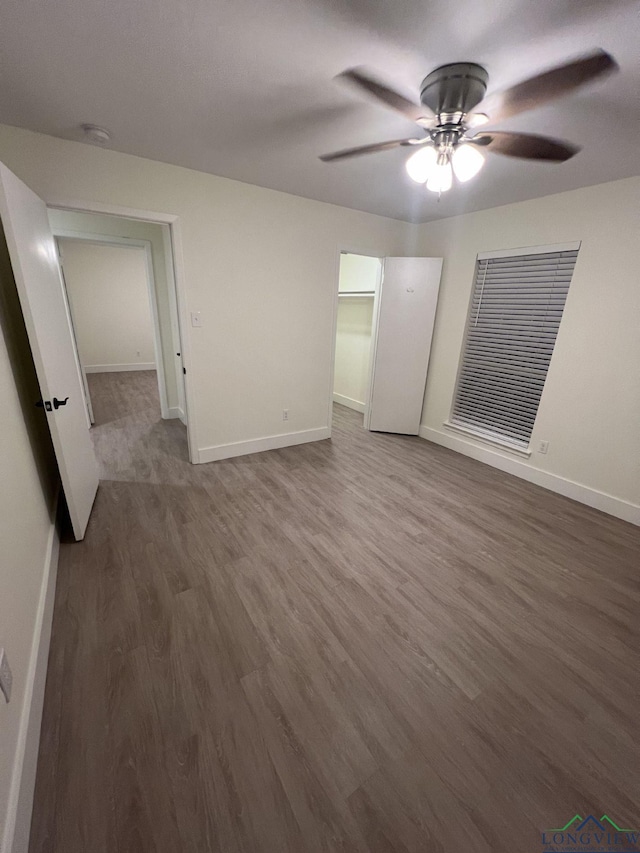 unfurnished bedroom featuring wood finished floors, a ceiling fan, and baseboards