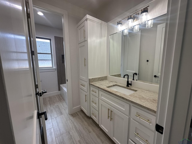 bathroom featuring bathing tub / shower combination, baseboards, and vanity